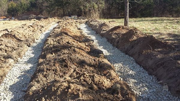 Траншеи для укладки дренажных труб отсыпанные щебнем